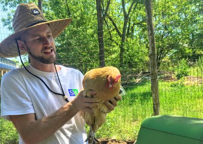 Image of Seeds volunteer holding chicken