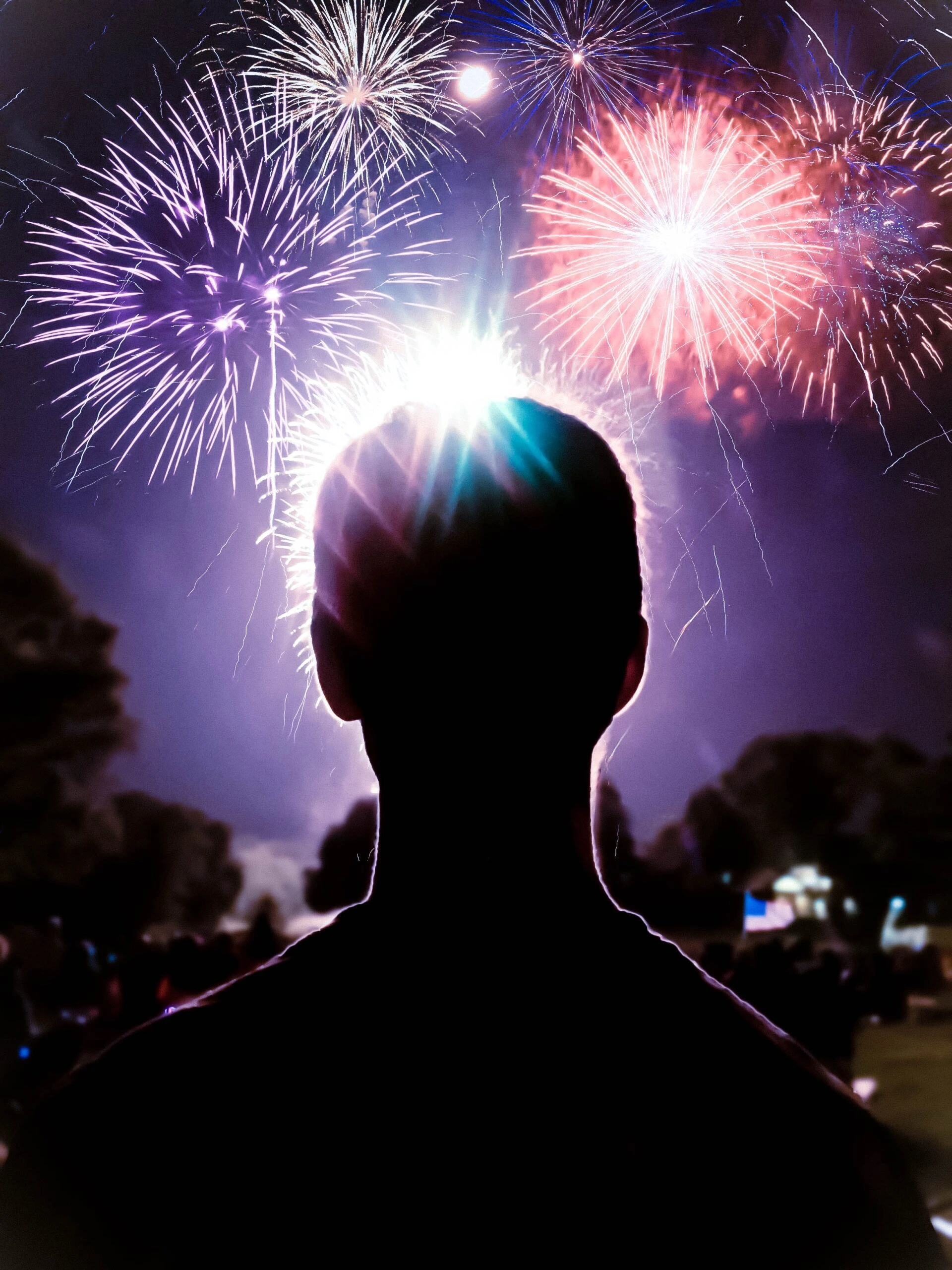 spenser-sembrat-man-in-foreground-looking-at-fireworks-display-unsplash-scaled