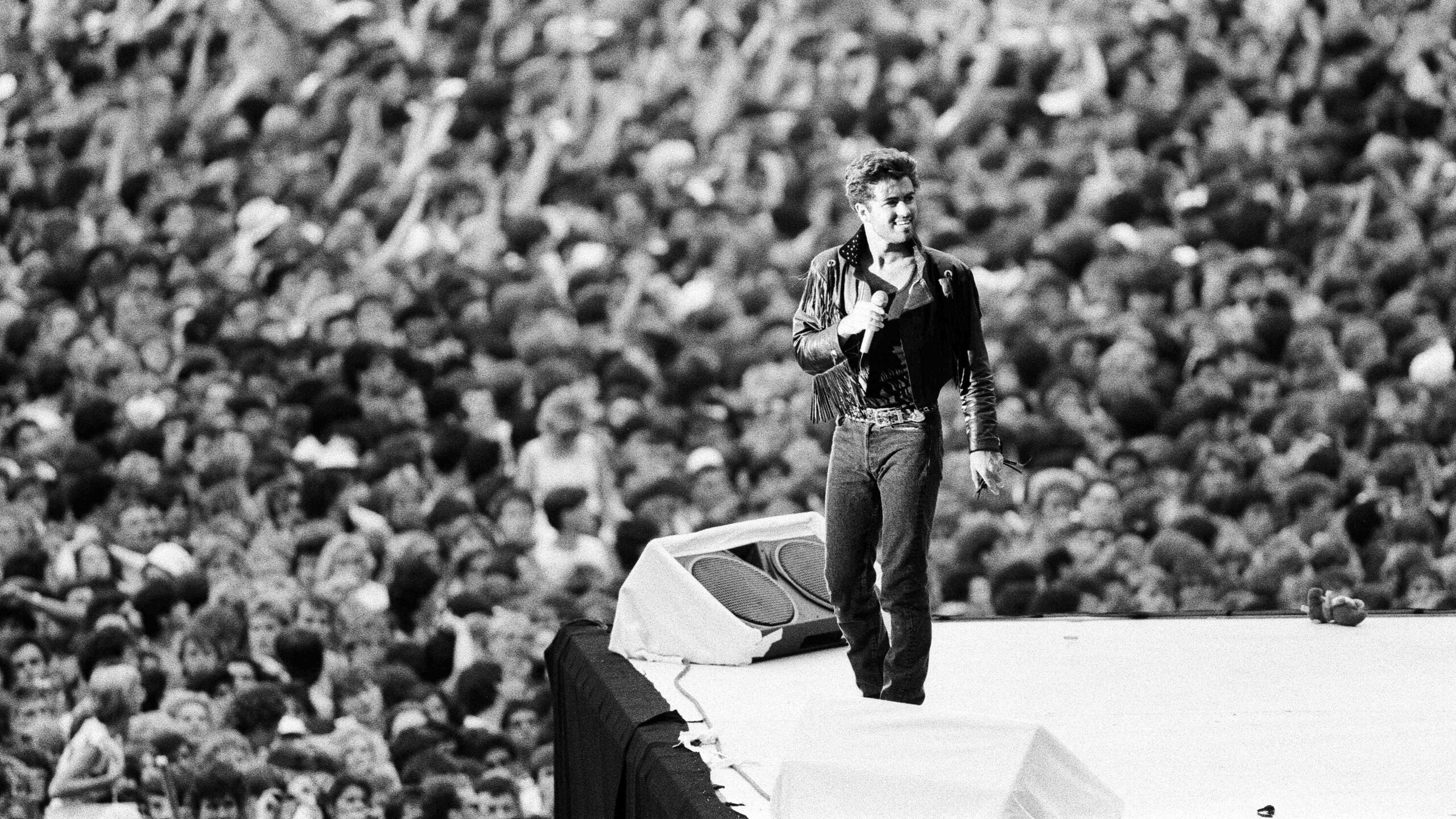 George Michael on stage with crowd behind
