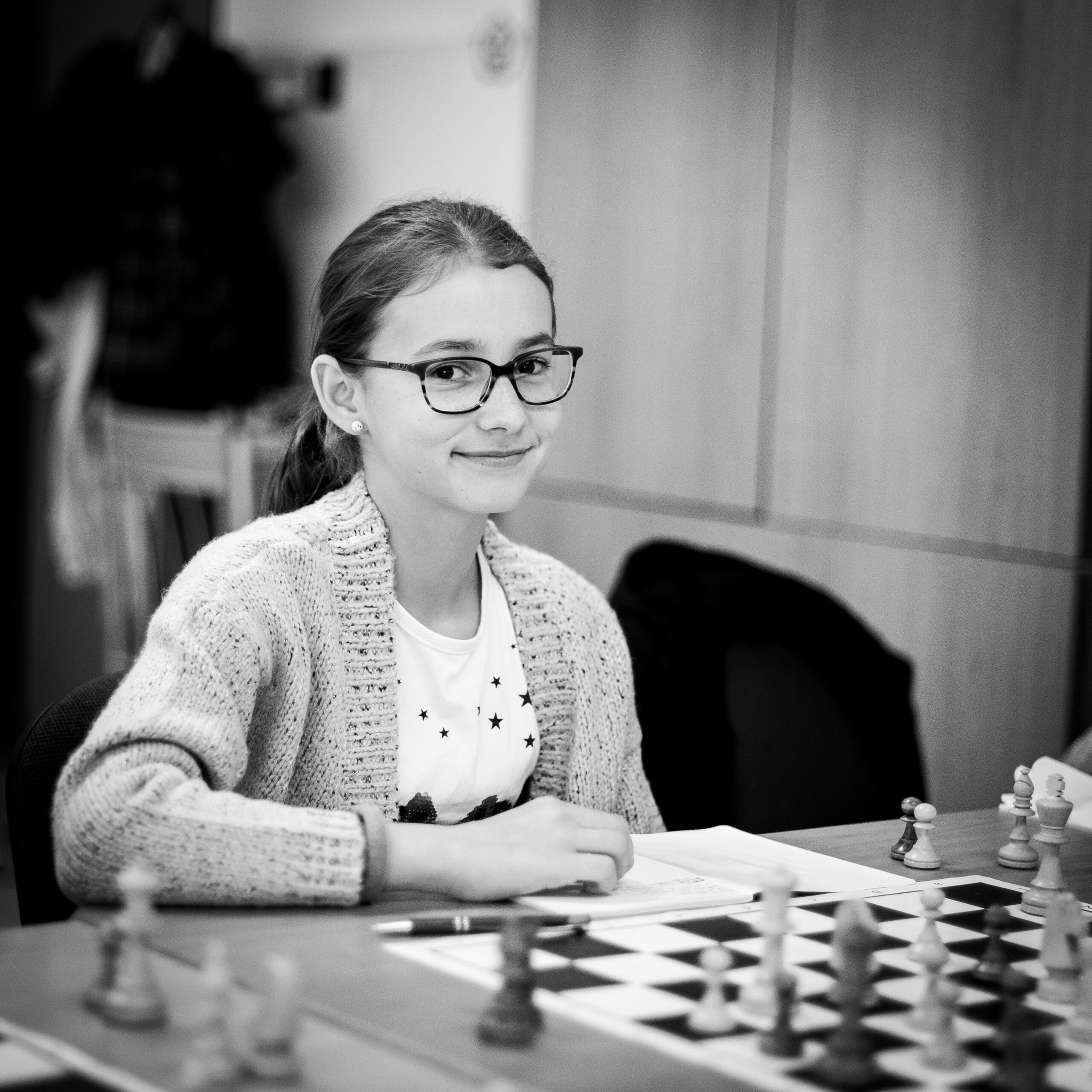 michal-vrba-young lady sitting at chess table-unsplash (1)