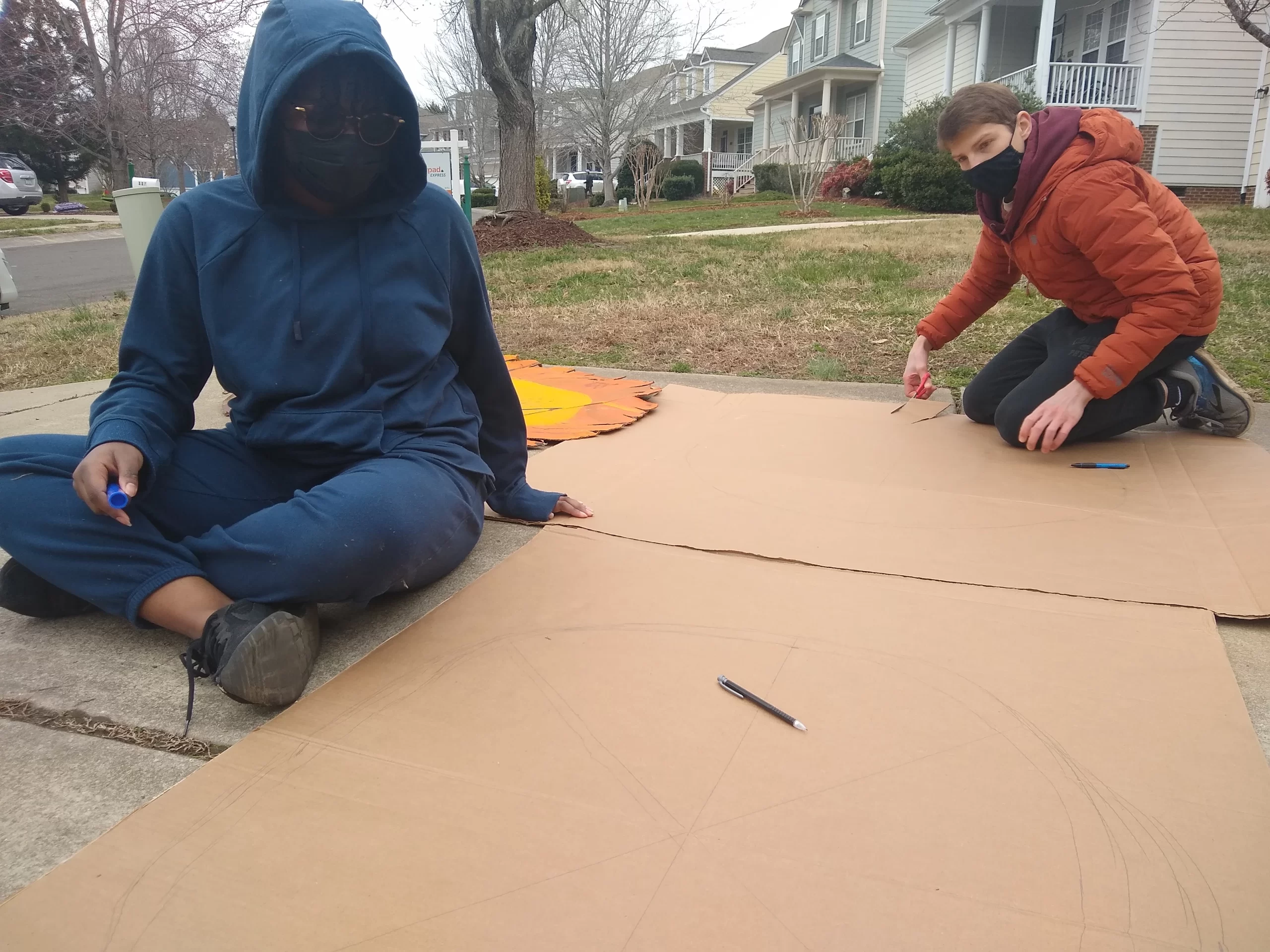 Kennedy and Jasper making mask for 1,2,3 Puppetry at Sol Ramirez drivweay