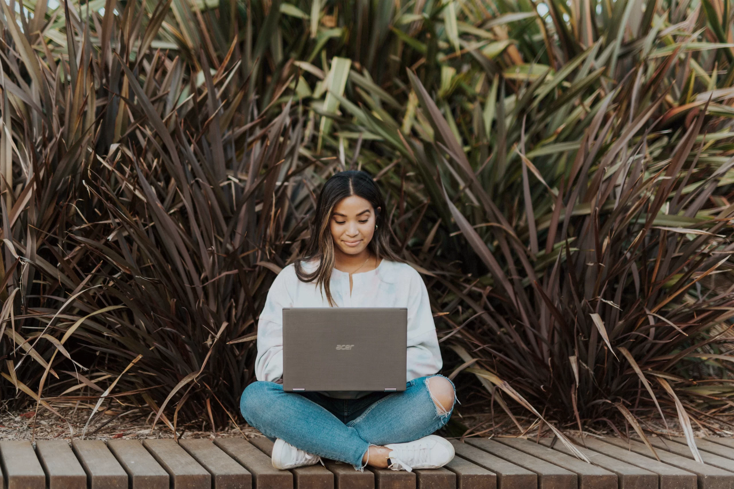 windows-Woman sitting on dock with laptop in lap -unsplash