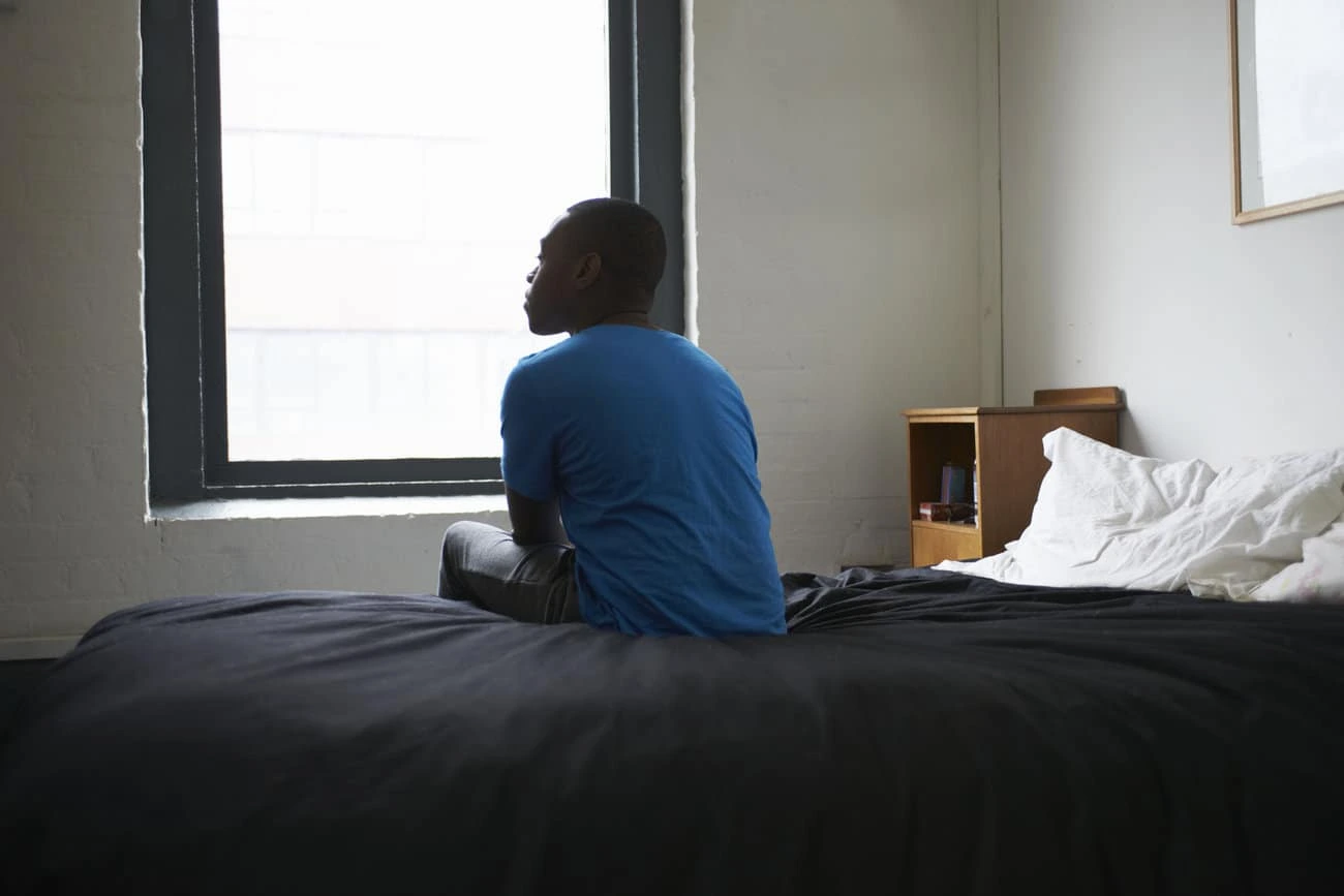 lonely-1_custom-Man on bed alone in room looking out window webp lonely-1_custom-Man on bed alone in room looking out window webp