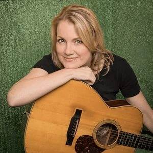Kelly Willis sitting in chair with Acoustic guitar on lap wearing black t shirt Kelly Willis sitting in chair with Acoustic guitar on lap wearing black t shirt