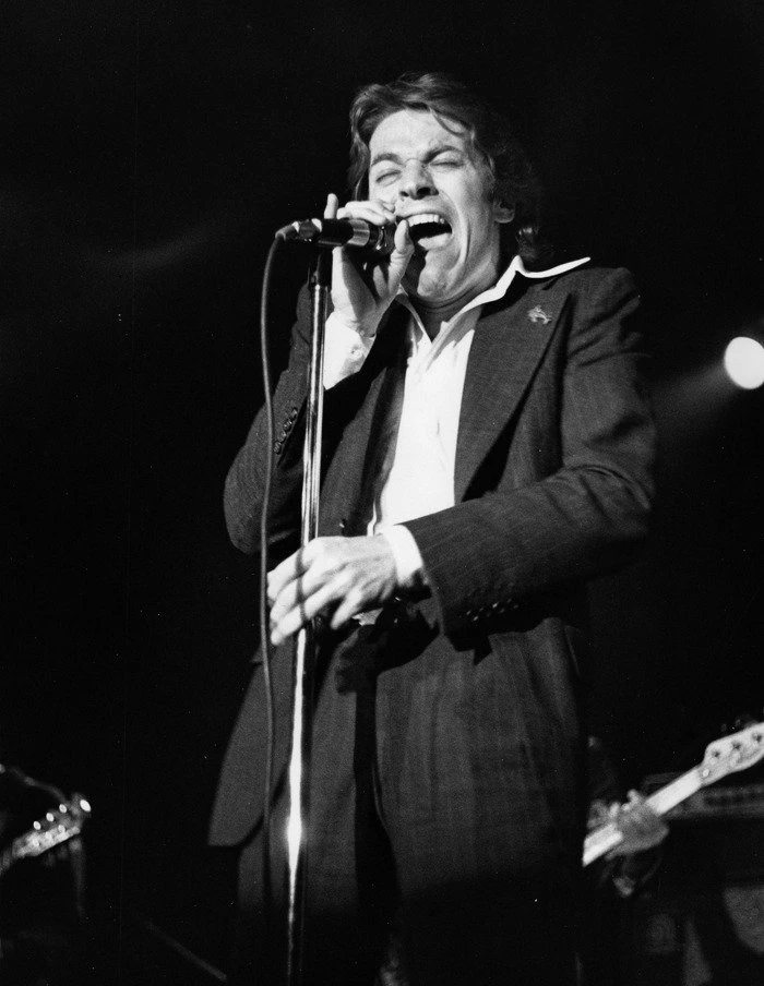The photographer's description says: "During a bicentennial performance at the Sunset Strip Roxy, Robert Palmer strongly reacts to a premonition of his eminent addiction to love."<br />
Date	23 June 1976, 12:05<br />
Source	Robert Palmer<br />
Author	Nathan Callahan from Southern California, USA. This file is licensed under the Creative Commons Attribution 2.0 Generic license.<br />
You are free:<br />
to share – to copy, distribute and transmit the work<br />
to remix – to adapt the work<br />
Under the following conditions:<br />
attribution – You must give appropriate credit, provide a link to the license, and indicate if changes were made. You may do so in any reasonable manner, but not in any way that suggests the licensor endorses you or your use.